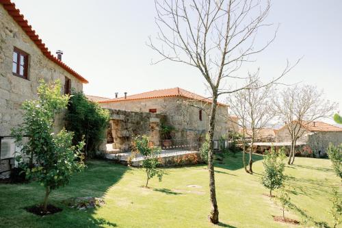 an old stone house with a yard with trees at D'Autor Village in Valadares