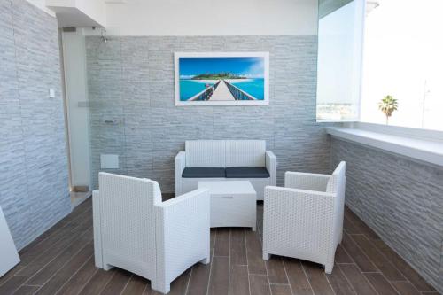 a waiting room with white chairs and a table at Vista Mare in Mola di Bari