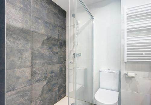 エステポナにあるStylish 2 Bedroom Apartment in Estepona Old Townのトイレとガラスのシャワー付きのバスルーム