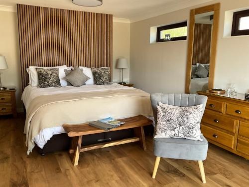 a bedroom with a bed and a chair and a table at The Garden Room at Amelia Cottage in Whiting Bay