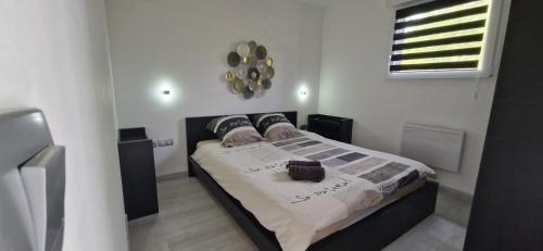 ein Schlafzimmer mit einem Bett in einem Zimmer in der Unterkunft Au petit canal de COLMAR 2 in Kunheim