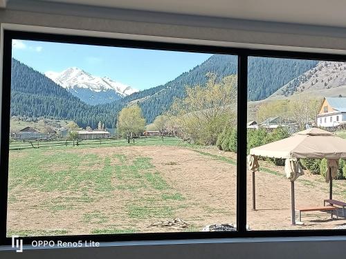 a window with a view of a field and mountains at Hotel Kolsay Eki Agayindy in Kurmenty