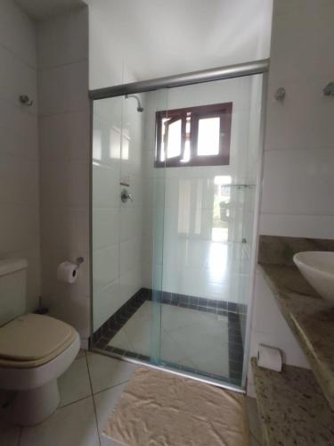 a bathroom with a shower with a toilet and a sink at Apartamento com Jacuzzi na Praia de Pipa. in Pipa