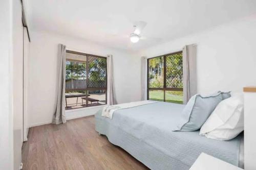 a white bedroom with a bed and a window at Hervey Bay Shelly Beach Stay ,Pet Friendly 300m to beach in Torquay