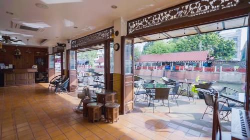 a restaurant with a patio with tables and chairs at Korbua House in Bangkok