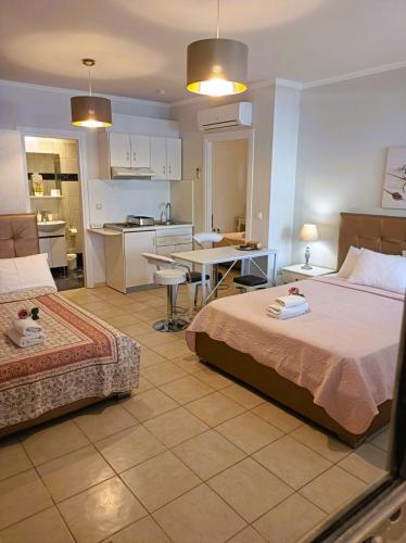 a bedroom with two beds and a kitchen with a table at Villa Thassos Paradise in Limenas