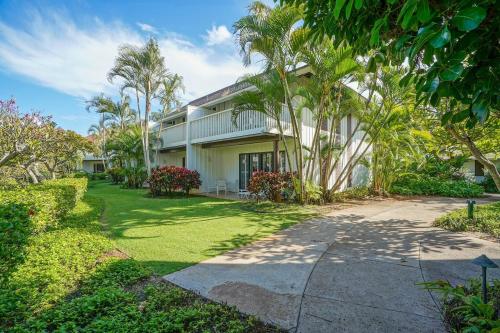 a house with palm trees in front of it at KP40 1Br Poipu Corner Condo with AC, Steps to the Beach in Koloa