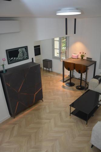 un soggiorno con tavolo e pavimento in legno di Maison Rascas - Centre historique - Air conditioning- wifi ad Avignone