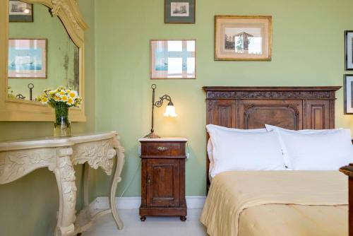 - une chambre avec un lit, une table et un miroir dans l'établissement Villa Maria-Syros, à Ermoúpoli