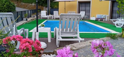 a group of chairs sitting next to a swimming pool at Casa do Toucedo - Encanto da Natureza Caniçada / Gerês in Caniçada