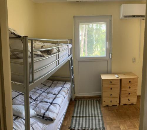 1 dormitorio con 2 literas y ventana en Helena Vendégház, en Siófok