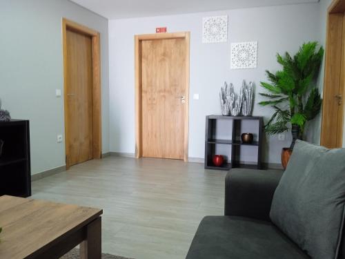 a living room with a couch and a wooden door at Casa do Toucedo - Encanto da Natureza Caniçada / Gerês in Caniçada