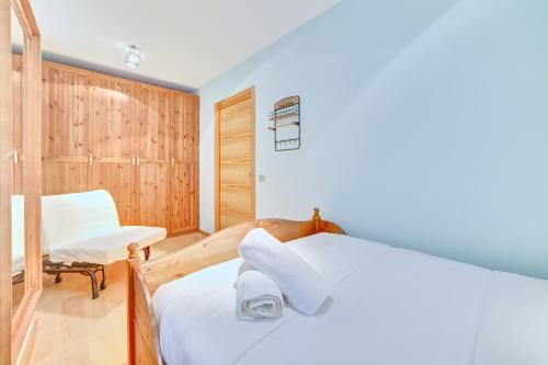 a bedroom with a white bed and a chair at Apartamento la Laurel by Clabao in Logroño