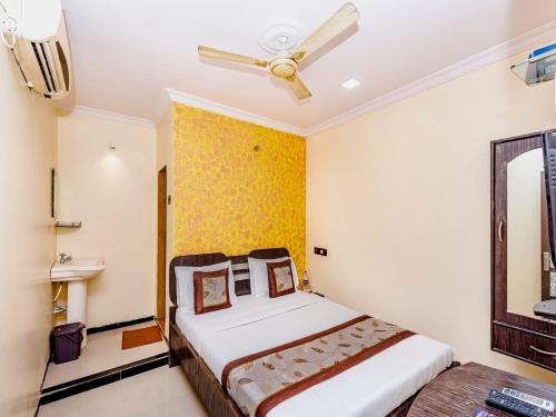 a bedroom with a bed and a ceiling fan at NEW ROYAL LODGE in Mangalore