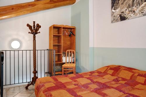 um quarto com uma cama e uma cadeira em Arnica Tano di Grich em Cesani