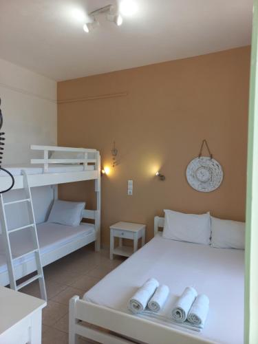 a bedroom with two bunk beds and a ladder at Stafylos Rooms in Stafylos
