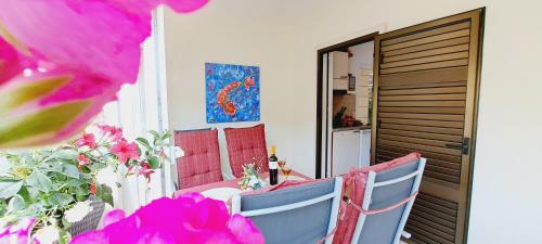 d'une table et de chaises sur un balcon orné de fleurs roses dans l'établissement Apartments DARIJA & PERO, à Pučišća