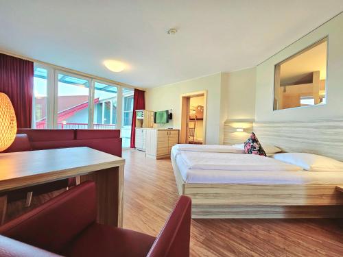 a hotel room with two beds and a table and chairs at Familienhotel Trebesingerhof in Trebesing