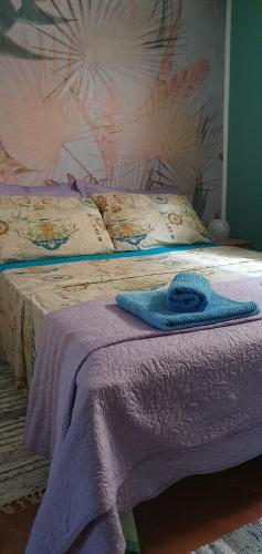 a bed with a purple blanket on top of it at Studio Apartman Marti in Kostrena