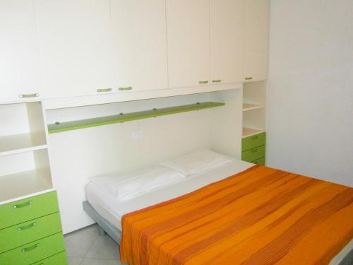 カオルレにあるVillaggio dei Fiori - Agenzia Cocalの小さなベッドルーム(ベッド1台、キャビネット付)
