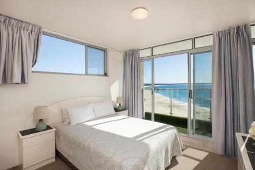 een slaapkamer met een bed en een groot raam bij Oceanic 29 in Forster