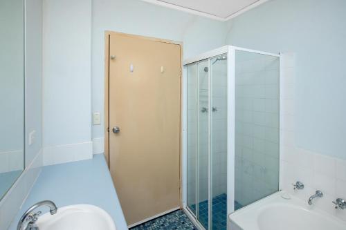 een badkamer met een douche, een toilet en een wastafel bij Oceanic 29 in Forster
