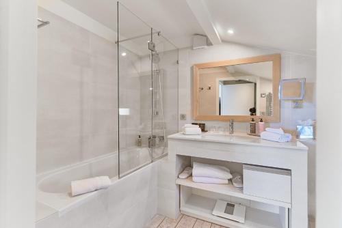 uma casa de banho branca com um lavatório e um chuveiro em Villa L'Arche em Bidart