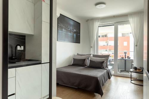 ein Wohnzimmer mit einem Bett und eine Küche in der Unterkunft Apartman Elena in Split