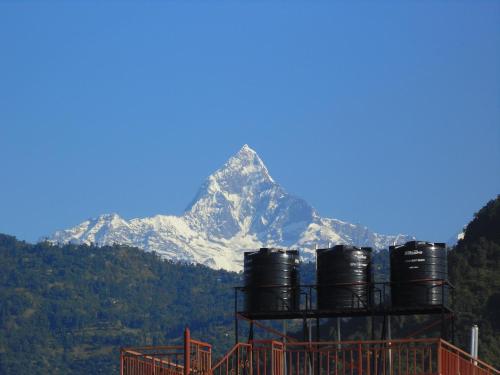 a snow covered mountain in the distance with a train at R&R Guest House in Pokhara