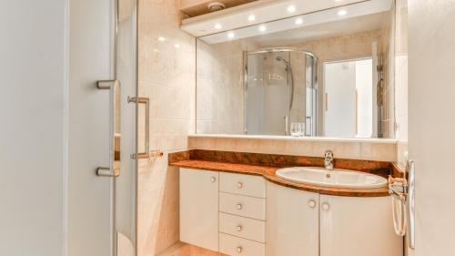 une salle de bain avec un lavabo et un miroir dans l'établissement Port Lano - 3 - Appt lumineux 4-6 pers, au Cap d'Agde