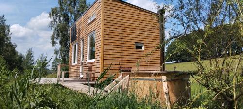 a small wooden building on a hill with a wooden ramp at Glamping sever in Mikulášovice