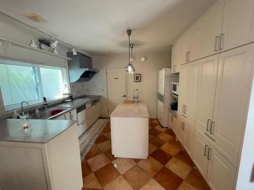 a large kitchen with white cabinets and a kitchen island at Maccha House Near Zenkoji Nagano in Nagano