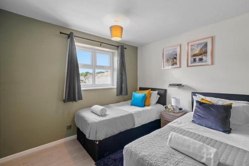 1 dormitorio con 2 camas y ventana en Stunning 3 bed Abode in Nuneaton- Sleeps 7 en Nuneaton
