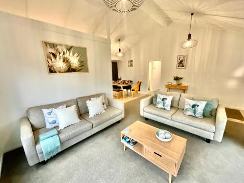 a living room with two couches and a coffee table at Perfect On The Park in Tauranga