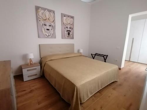 1 dormitorio con 1 cama y 2 cuadros en la pared en Appartamento I Mori, en Cassibile