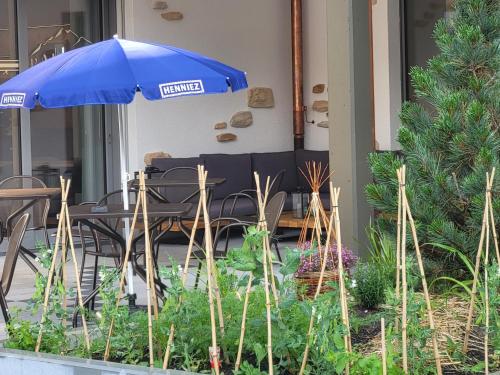 a patio with a table and an umbrella at Boutique hôtel Corbetta - SPA 60m2 - La montagne à 5 minutes de l'autoroute A12 aux Paccots sur Montreux - NOUVEAU Loft familial - Profitez du Lac Léman et des montagnes en même temps in Les Paccots