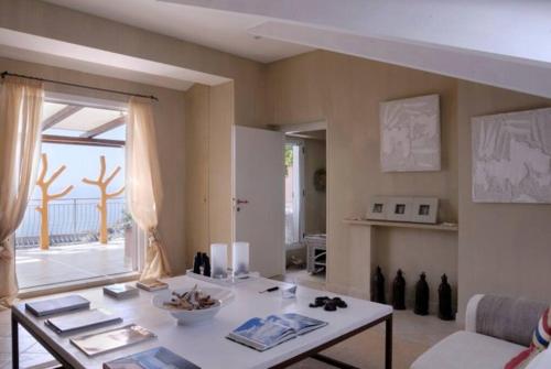 sala de estar con mesa y ventana grande en COCOSEA: Un attico con vista mozzafiato, en Maratea