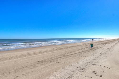 a beach with a sign in the sand and the ocean at Unsearchable Colony V in Port Aransas