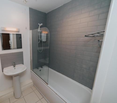 ein Badezimmer mit Dusche und Waschbecken in der Unterkunft Causeway Coast Sea Shore Apartment - Ballycastle in Ballycastle
