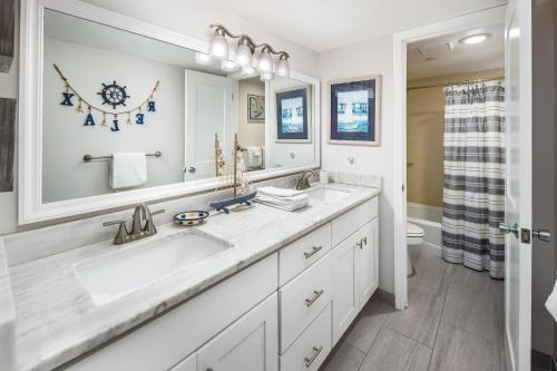 baño con lavabo y espejo grande en Nautilus 2510 Gulf View 2 Bedroom 5th Floor Free Beach Service en Fort Walton Beach