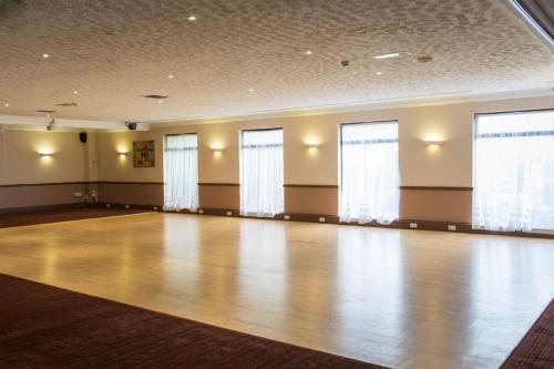 a large room with a wooden floor and windows at The Waterside in Peterhead