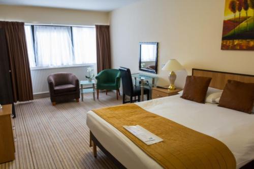 a hotel room with a bed and a table and chairs at The Waterside in Peterhead