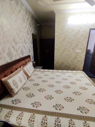 a bedroom with a bed with a bedspread and pillows at Sukh Sagar Hotel in Jaipur