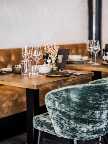 a wooden table with glasses and a laptop on it at Lindenhuys Logies in Sint-Oedenrode