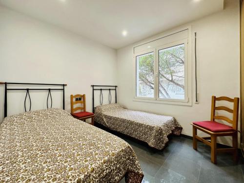 a bedroom with two beds and a window at Paradis CostaBravaSi in Platja d'Aro