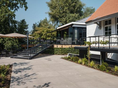 a building with stairs leading to a patio at Lindenhuys Logies in Sint-Oedenrode