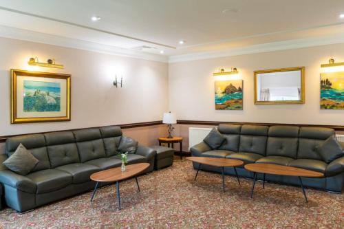 a waiting room with couches and tables and paintings at The Waterside in Peterhead
