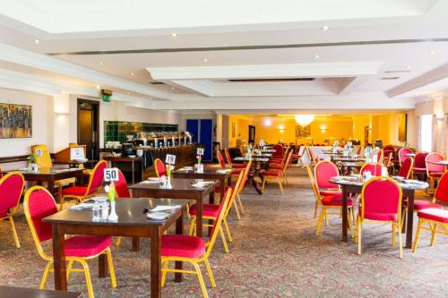a restaurant with wooden tables and red chairs at The Waterside in Peterhead
