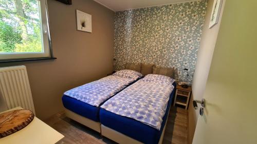 um pequeno quarto com uma cama e uma janela em Belle - Mooi Zuid Limburg em Simpelveld