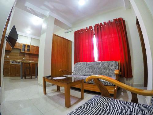 ein Wohnzimmer mit einem Stuhl und einem roten Vorhang in der Unterkunft Bello-Oriente-II in Iquitos